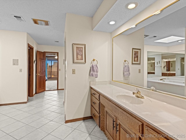 bathroom featuring baseboards, a textured ceiling, vanity, and tile patterned flooring