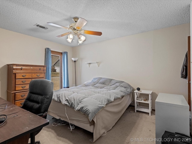 bedroom featuring visible vents, light colored carpet, a ceiling fan, and a textured ceiling