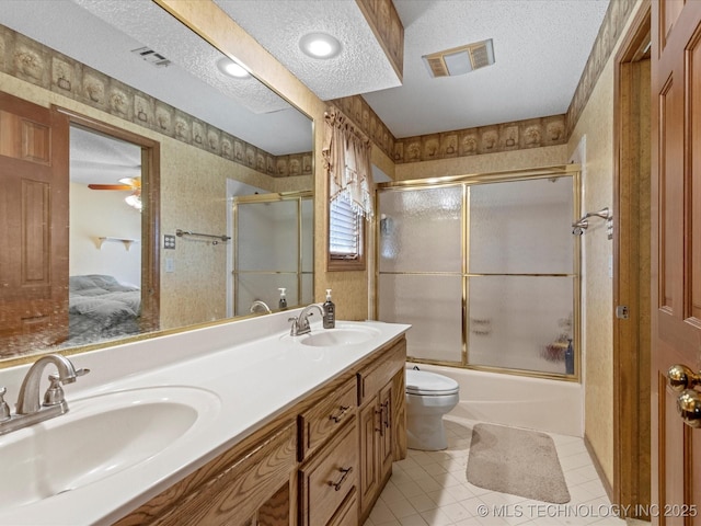 bathroom featuring a sink, visible vents, a textured ceiling, and wallpapered walls