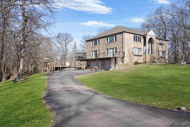 view of home's exterior with aphalt driveway, a lawn, a deck, and an attached garage