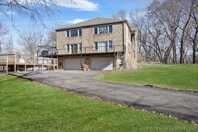 view of front facade with brick siding, an attached garage, driveway, and a front yard