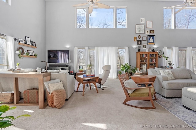 carpeted living room featuring a high ceiling and ceiling fan