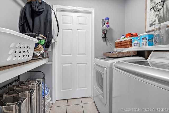 laundry room featuring light tile patterned flooring, laundry area, and separate washer and dryer