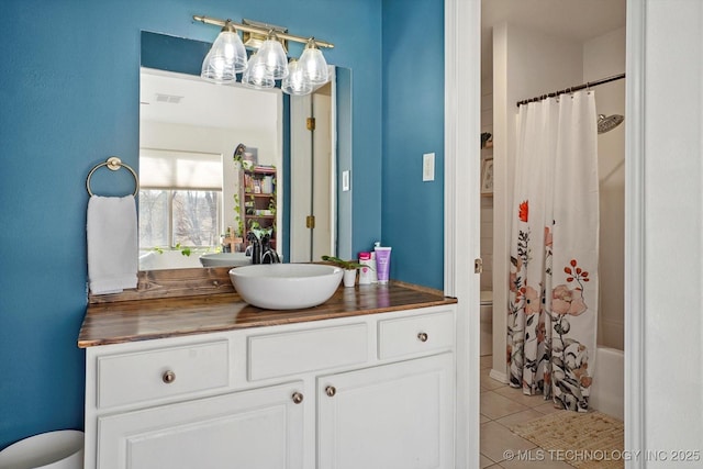 bathroom with tile patterned flooring, shower / bathtub combination with curtain, toilet, and vanity