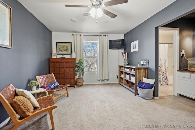 living area featuring visible vents, baseboards, carpet, and a ceiling fan