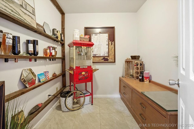 interior space featuring light tile patterned flooring and baseboards