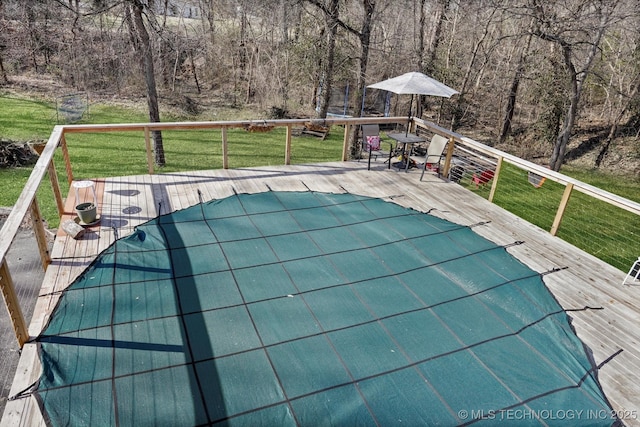 view of pool featuring a lawn and a deck