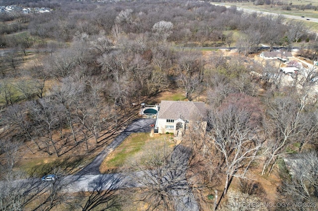 drone / aerial view featuring a wooded view