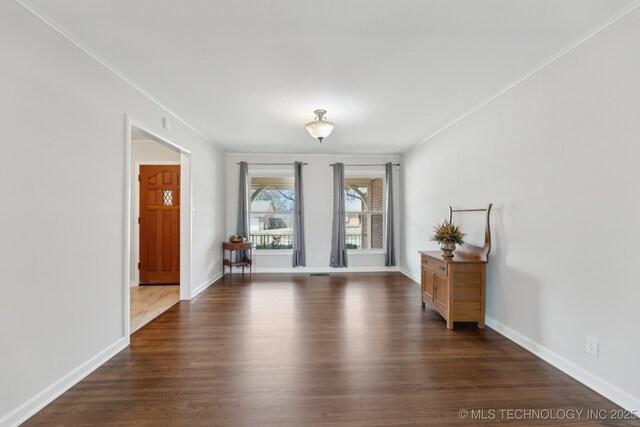 unfurnished room with crown molding, dark wood-style floors, and baseboards