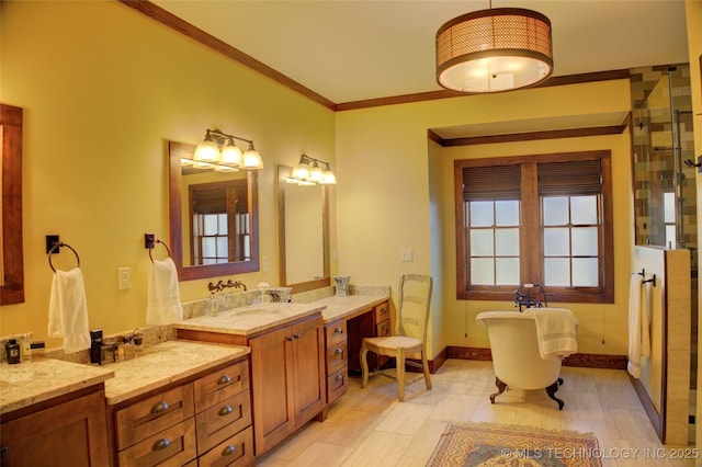 full bath featuring a shower with door, crown molding, baseboards, a soaking tub, and vanity