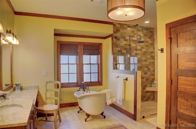 bathroom with baseboards, walk in shower, a freestanding bath, ornamental molding, and vanity