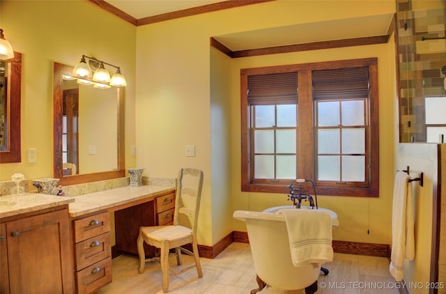 bathroom with baseboards, a soaking tub, ornamental molding, and vanity