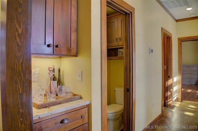 bathroom with visible vents, toilet, and baseboards