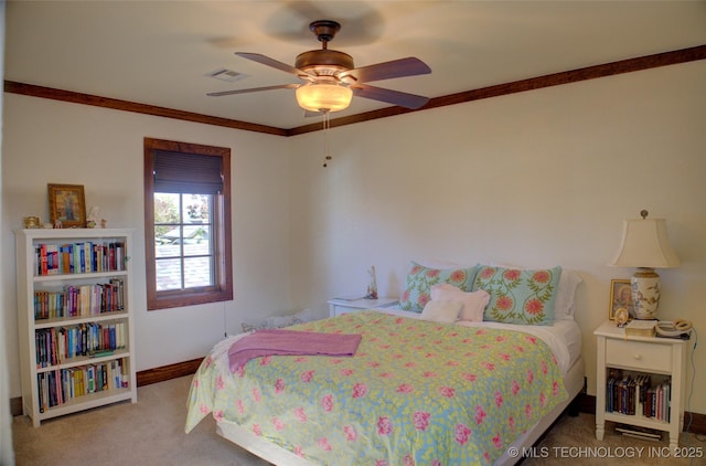 carpeted bedroom with visible vents, baseboards, ornamental molding, and a ceiling fan