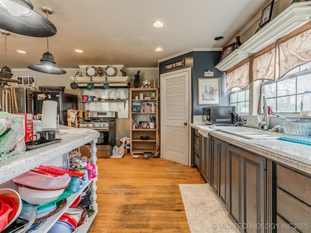 35575 W 87th Pl S, Mannford, OK 74044 - kitchen with stainless steel range with gas stovetop, a sink, light countertops, light wood finished floors, and ornamental molding