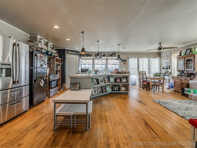 35575 W 87th Pl S, Mannford, OK 74044 - kitchen with ceiling fan, appliances with stainless steel finishes, light wood finished floors, light countertops, and a kitchen island