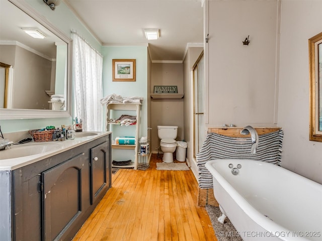 35575 W 87th Pl S, Mannford, OK 74044 - bathroom featuring double vanity, hardwood / wood-style flooring, toilet, ornamental molding, and a soaking tub
