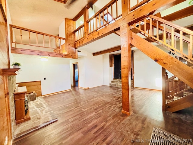 living area featuring stairs, baseboards, and wood finished floors