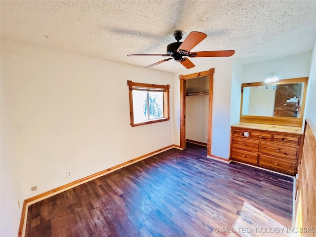 unfurnished bedroom with a closet, baseboards, a textured ceiling, and wood finished floors