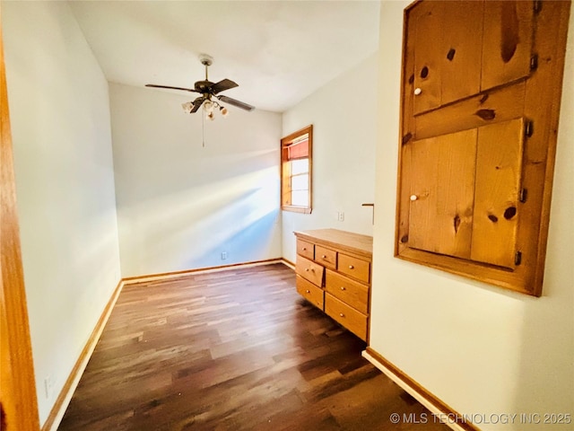 unfurnished bedroom featuring baseboards, dark wood-type flooring, and a ceiling fan