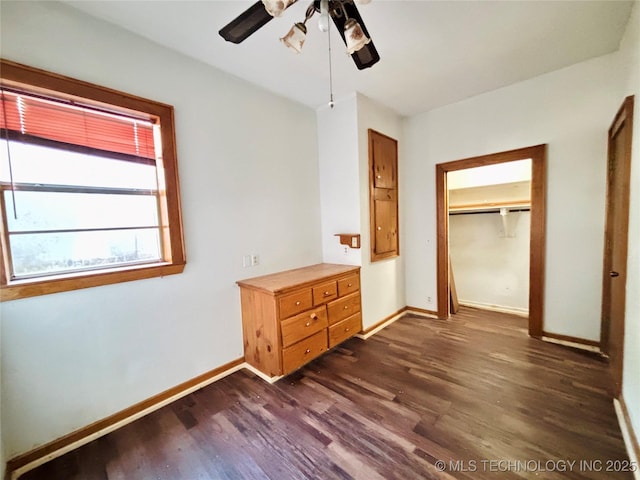 unfurnished bedroom featuring dark wood-type flooring, a ceiling fan, baseboards, and a closet