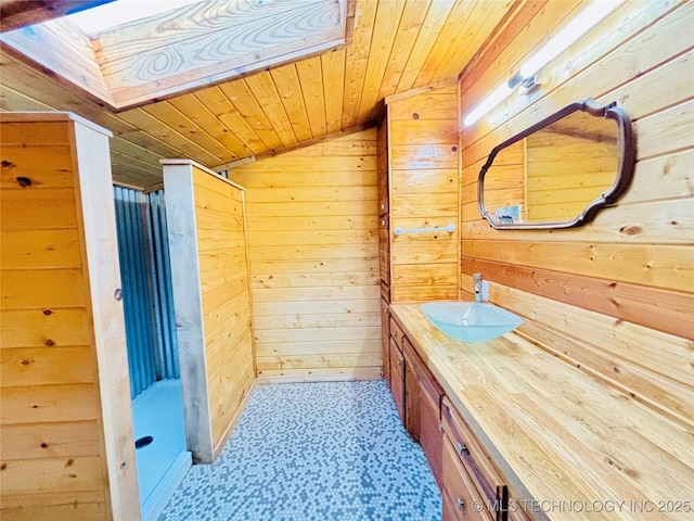 bathroom featuring vanity, wood walls, wooden ceiling, and vaulted ceiling