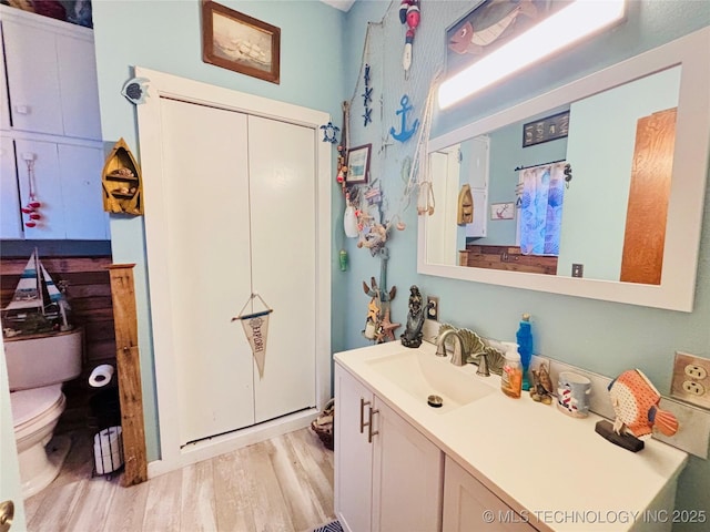 bathroom featuring vanity, toilet, and wood finished floors