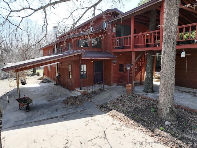 exterior space with an attached carport, a patio area, and metal roof