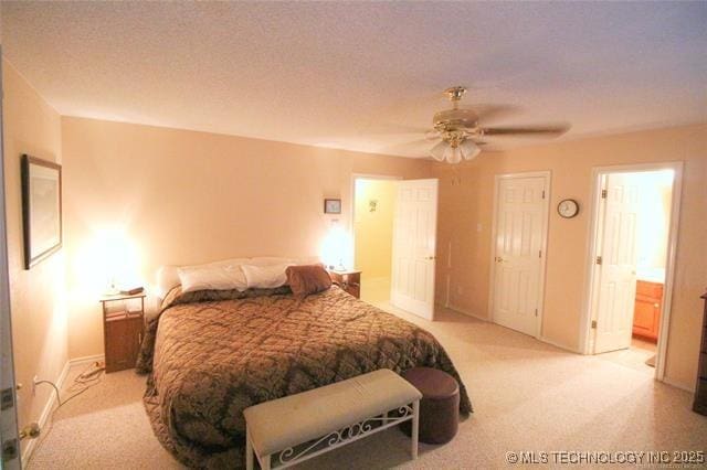 6786 Red Oak, Kingston, OK 73439 - bedroom with light carpet, ensuite bathroom, a ceiling fan, a textured ceiling, and baseboards