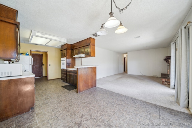 kitchen with white appliances, light countertops, under cabinet range hood, light colored carpet, and open floor plan