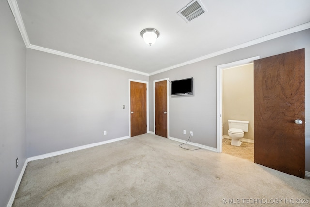 unfurnished bedroom with baseboards, visible vents, carpet floors, ornamental molding, and ensuite bathroom