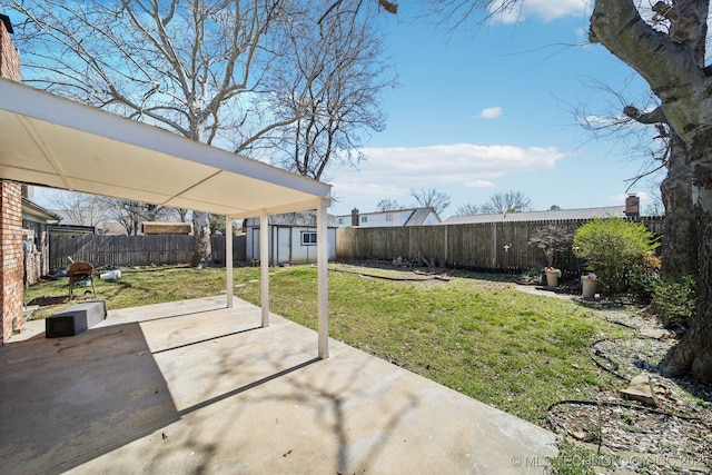 view of yard with an outbuilding, a fenced backyard, a storage shed, and a patio area