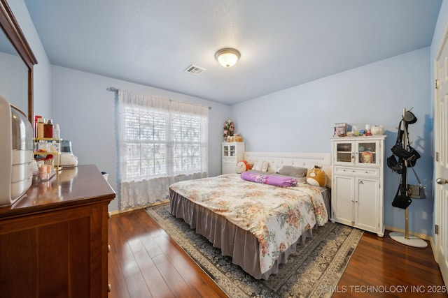 bedroom with visible vents, baseboards, and dark wood-type flooring