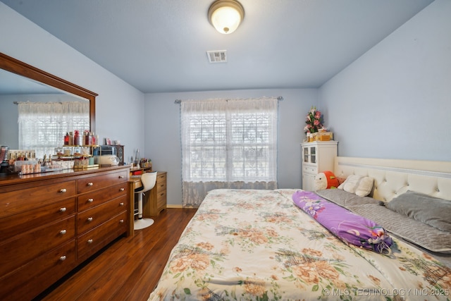 bedroom with dark wood-style floors and visible vents