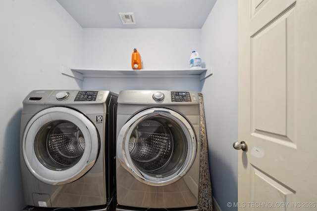 washroom featuring washing machine and clothes dryer, laundry area, and visible vents