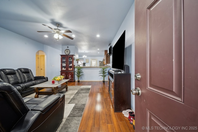 living area with recessed lighting, arched walkways, dark wood-style flooring, and ceiling fan