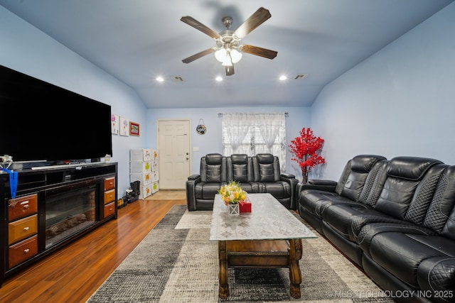 living area featuring dark wood-style floors, visible vents, ceiling fan, and lofted ceiling