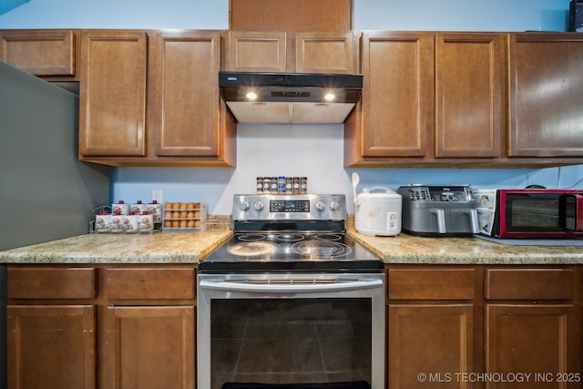 kitchen with under cabinet range hood, a toaster, stainless steel electric range, and brown cabinetry