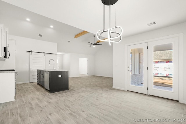 kitchen featuring visible vents, a sink, a barn door, appliances with stainless steel finishes, and light countertops