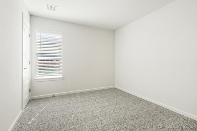 carpeted empty room with visible vents and baseboards