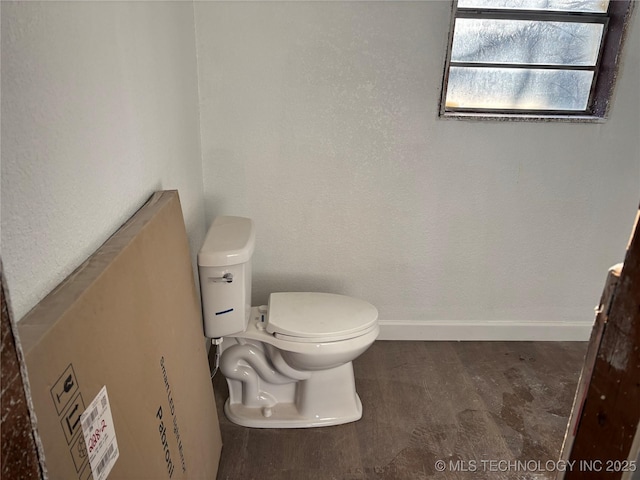 bathroom featuring baseboards and toilet