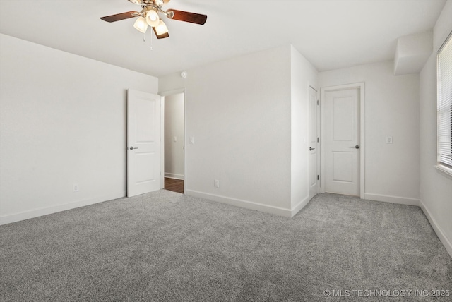 unfurnished bedroom with baseboards, carpet floors, and a ceiling fan