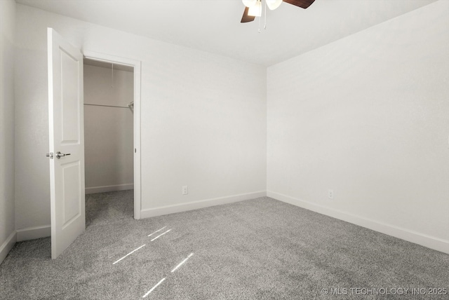 unfurnished bedroom featuring baseboards, carpet floors, and a spacious closet