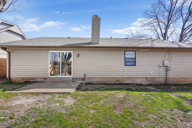 back of property with a patio, a yard, and a shingled roof