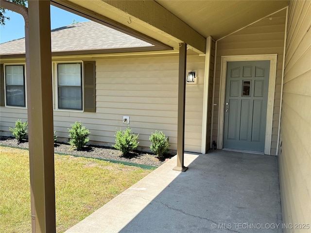 2426 S 104th E Ave, Tulsa, OK 74129 - view of exterior entry with roof with shingles and a lawn