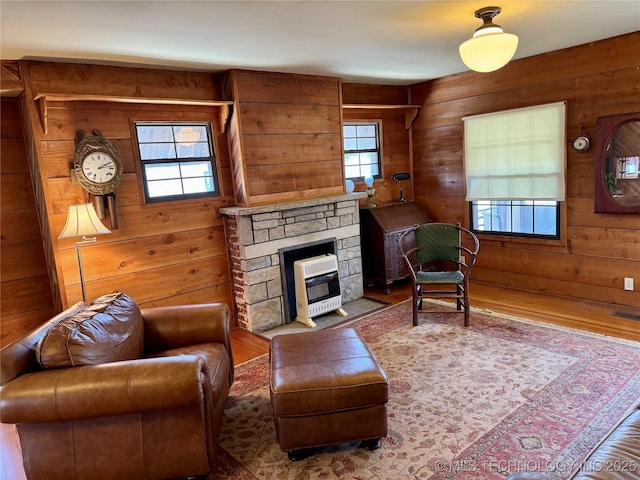 living area with wood finished floors, a fireplace, and wood walls