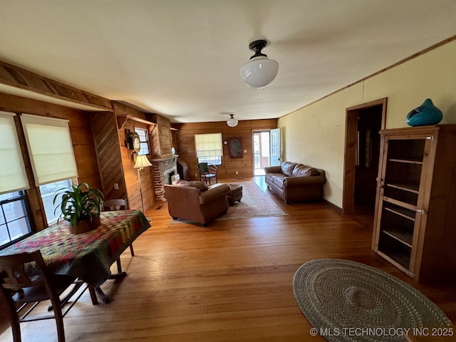 707 E 15th St, Okmulgee, OK 74447 - living area with wood walls, hardwood / wood-style floors, and a fireplace