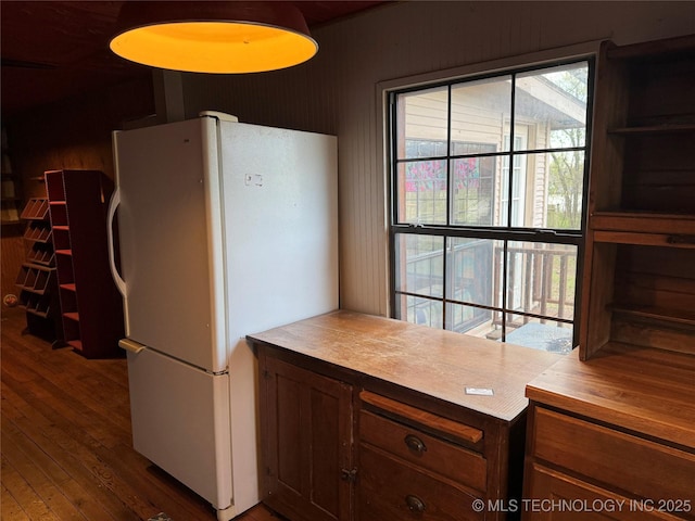 kitchen featuring hardwood / wood-style flooring, light countertops, and freestanding refrigerator