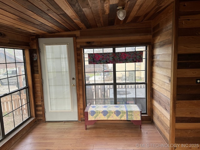 707 E 15th St, Okmulgee, OK 74447 - doorway with wood ceiling, wooden walls, plenty of natural light, and light wood-style floors