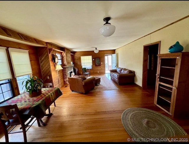 707 E 15th St, Okmulgee, OK 74447 - living area with wooden walls, hardwood / wood-style floors, and a fireplace